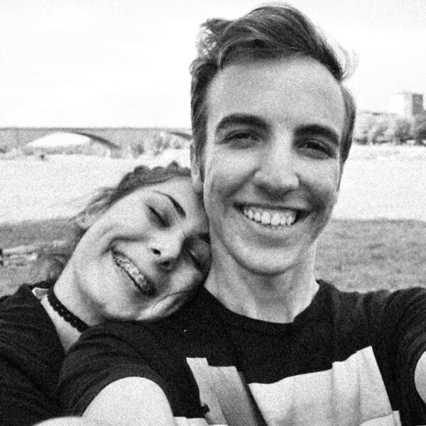 due ragazzi adolescenti sorridenti in una foto in bianco e nero con un ponte sullo sfondo